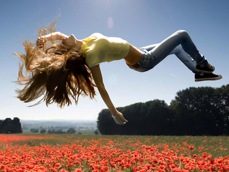 Woman jumping in poppy field