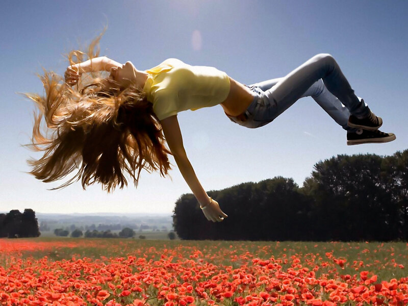 Woman jumping in poppy field