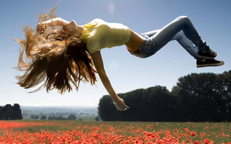 Woman jumping in poppy field