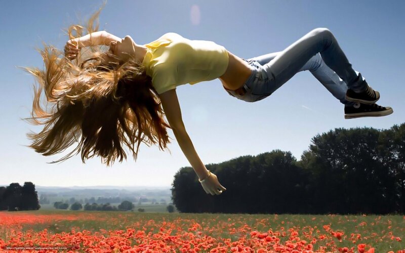 Woman jumping in poppy field