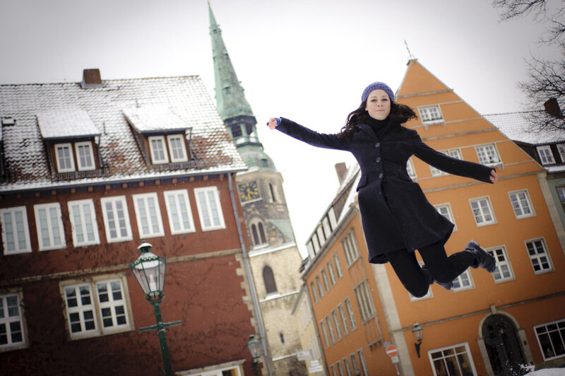 Woman jumping in snowy town