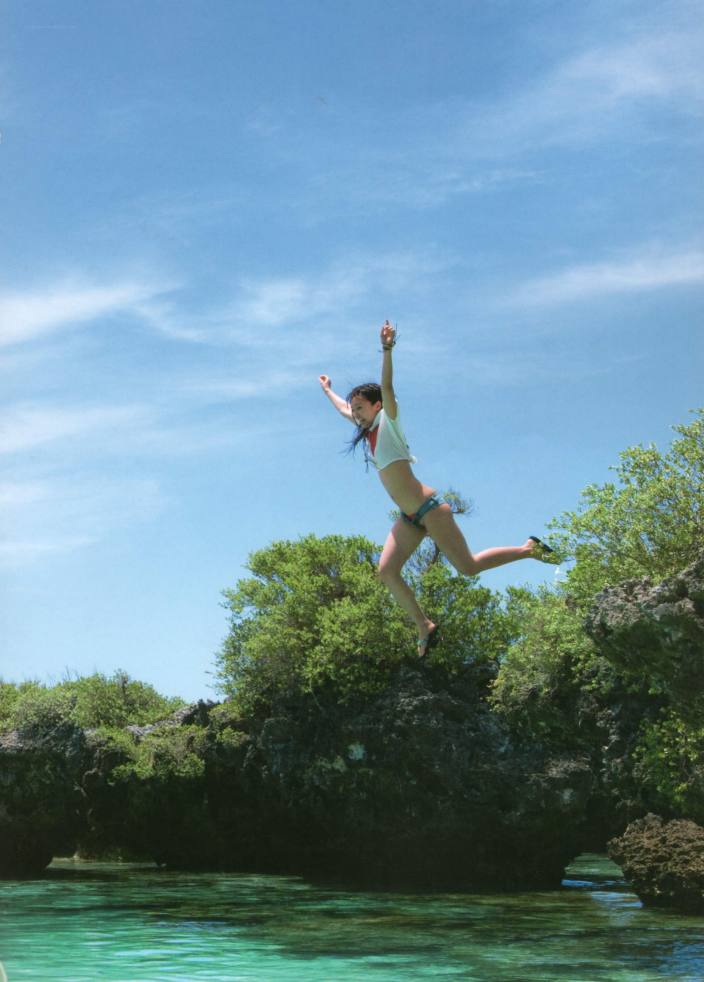 woman jumping into ocean