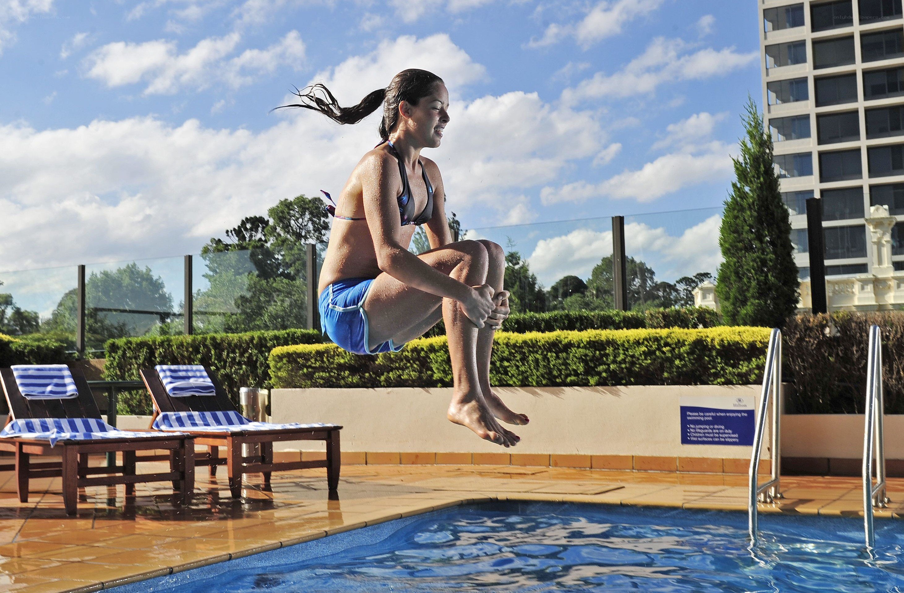 woman jumping into pool