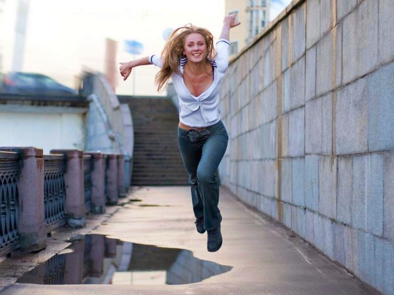 woman jumping on a bridge