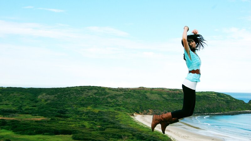 Woman jumping on a cliff