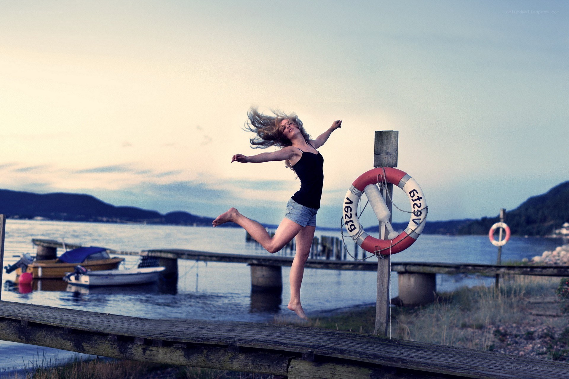 Woman jumping on a dock