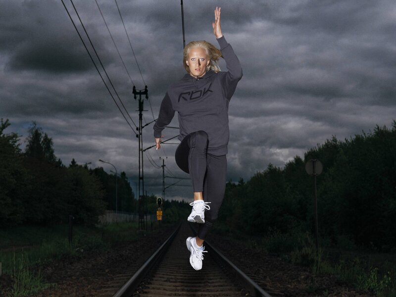 Woman jumping on train tracks