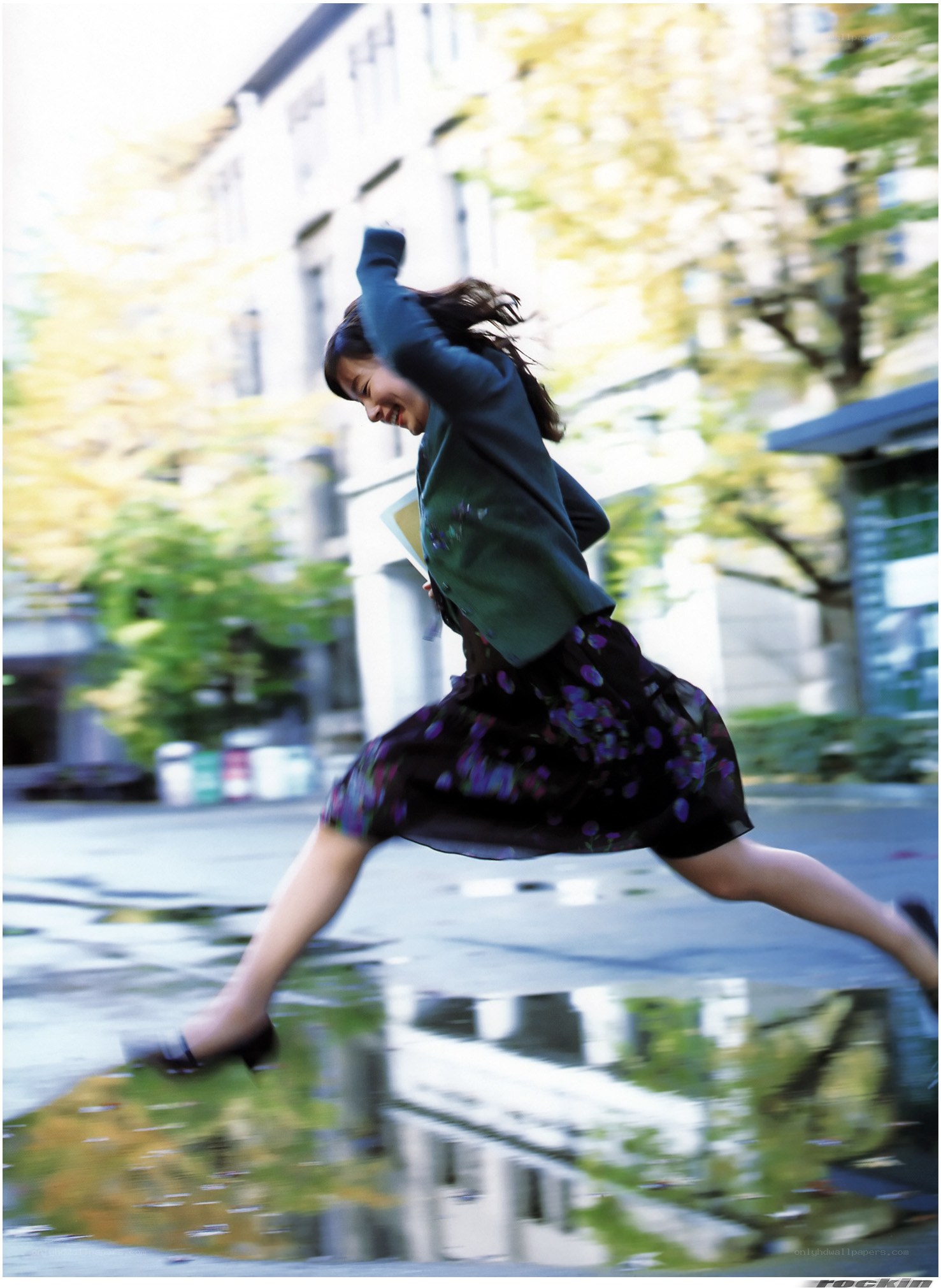 woman jumping over a puddle