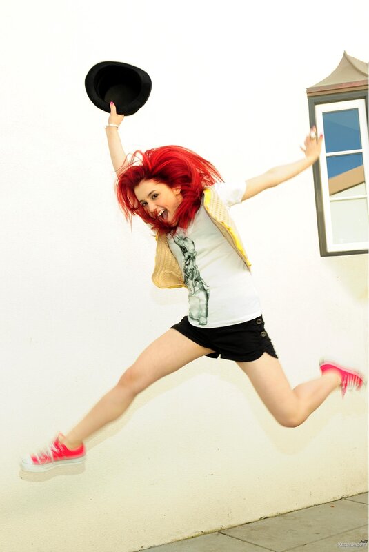 woman jumping with hat