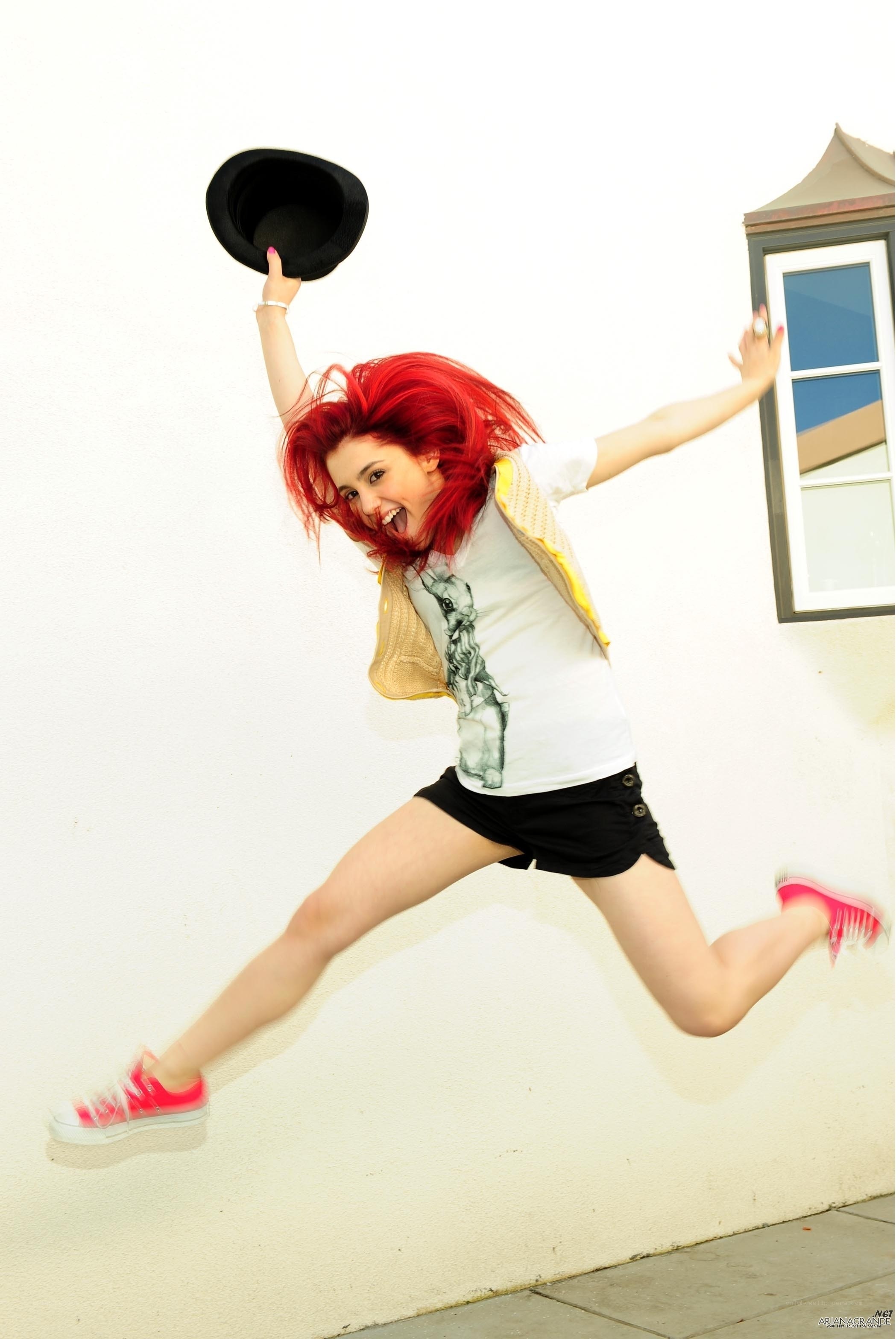 woman jumping with hat