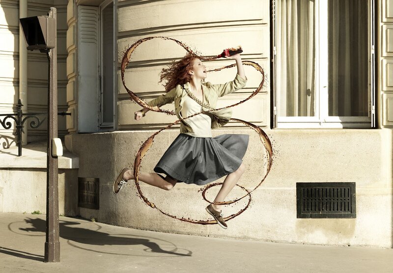 woman jumping with soda drink