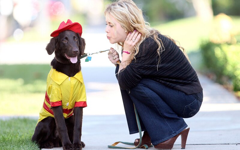 woman kissing dog in costume