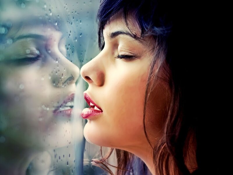 woman kissing rain-streaked glass