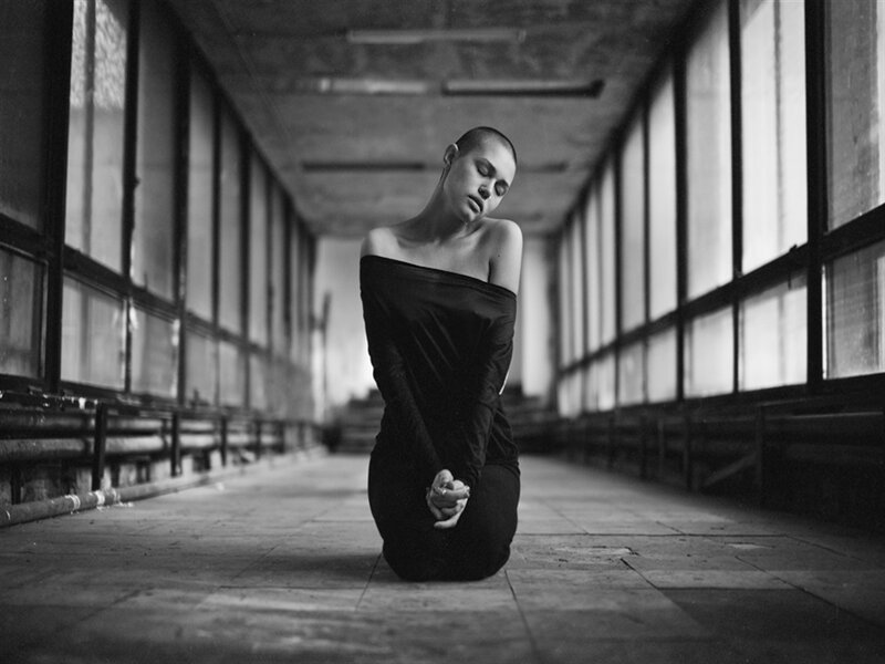 Woman Kneeling in Corridor