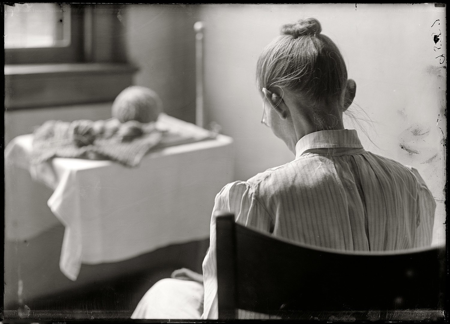 Woman knitting by a window