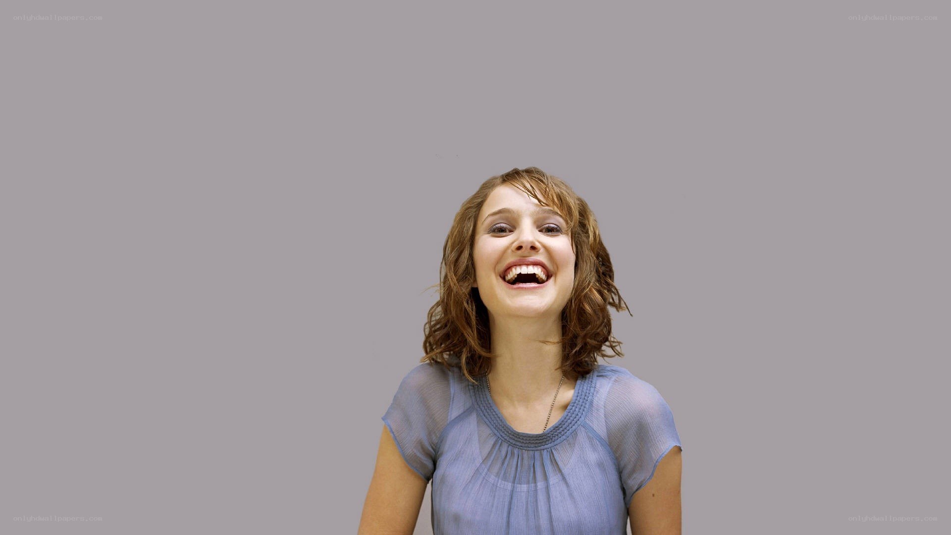 woman laughing against gray background