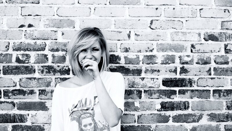 woman laughing by brick wall