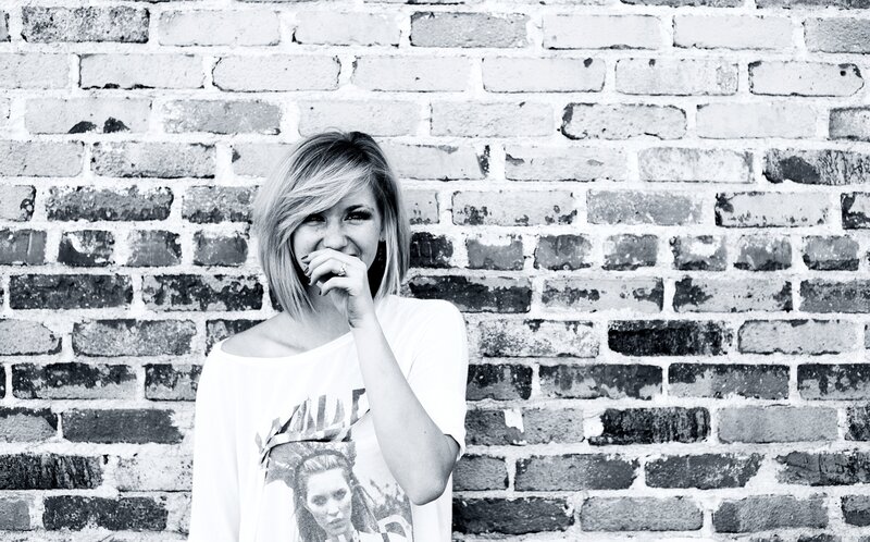 woman laughing by brick wall