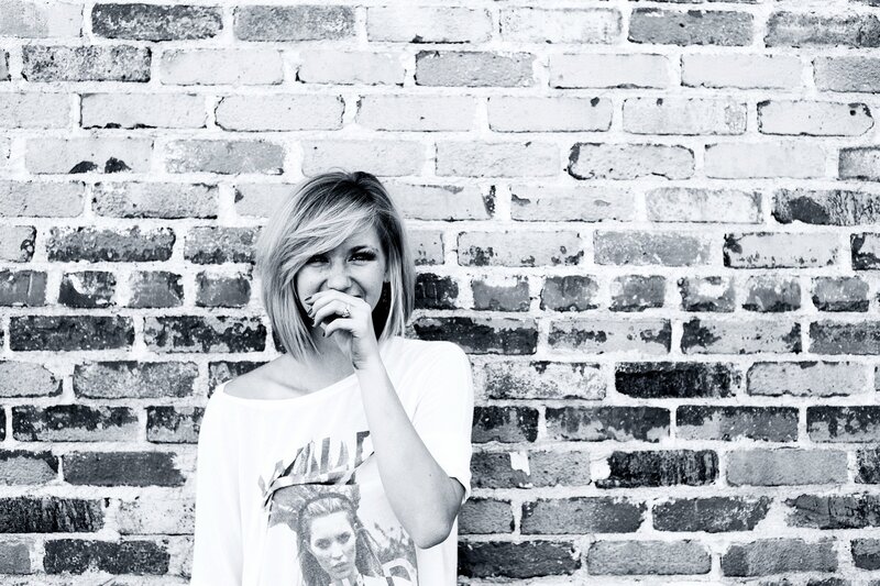 woman laughing by brick wall