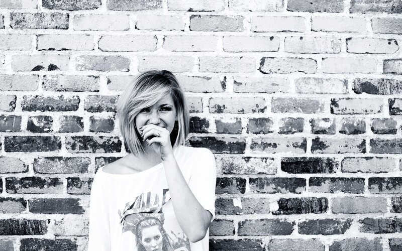 woman laughing by brick wall
