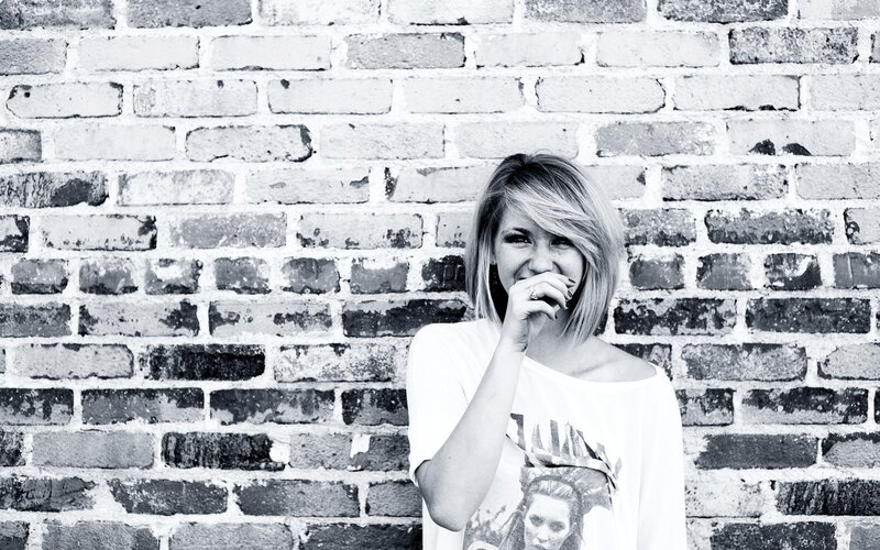 woman laughing by brick wall