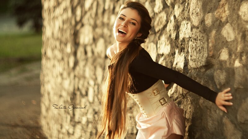 woman laughing by stone wall