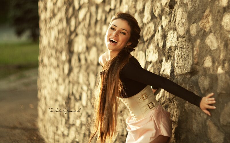 woman laughing by stone wall