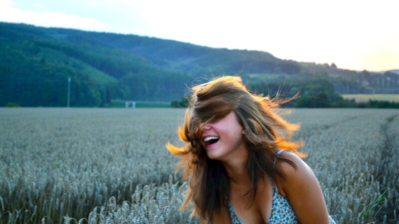 woman laughing in a wheat field
