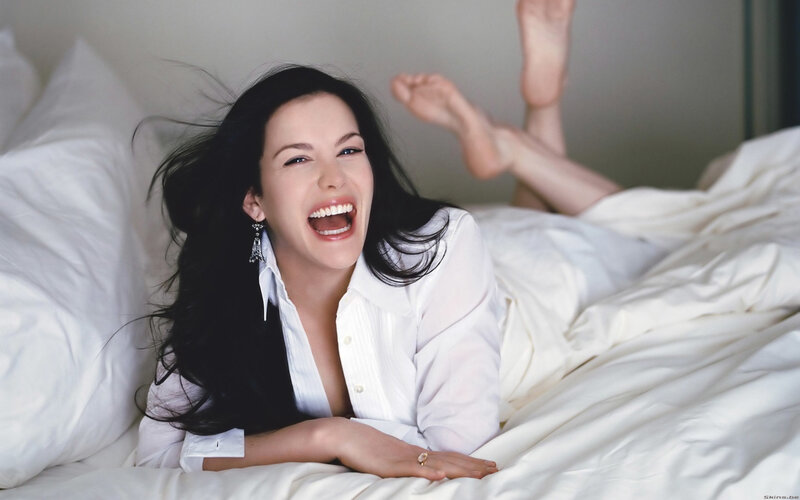 woman laughing in bed