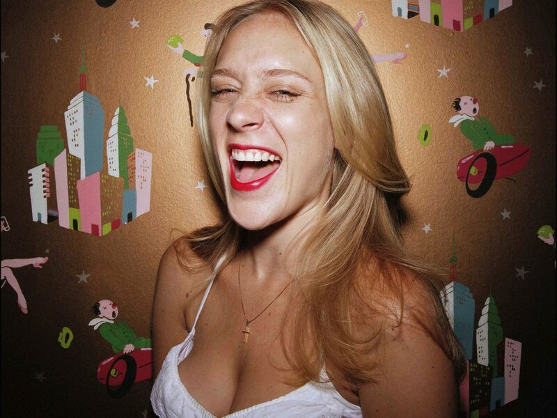 Woman laughing in front of cartoon wall