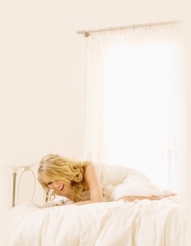 woman laughing on a bed
