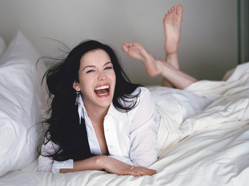 woman laughing on a bed