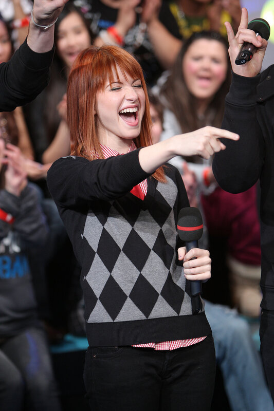 Woman laughing on stage with microphone