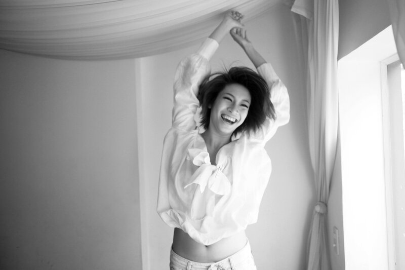 woman laughing with arms raised