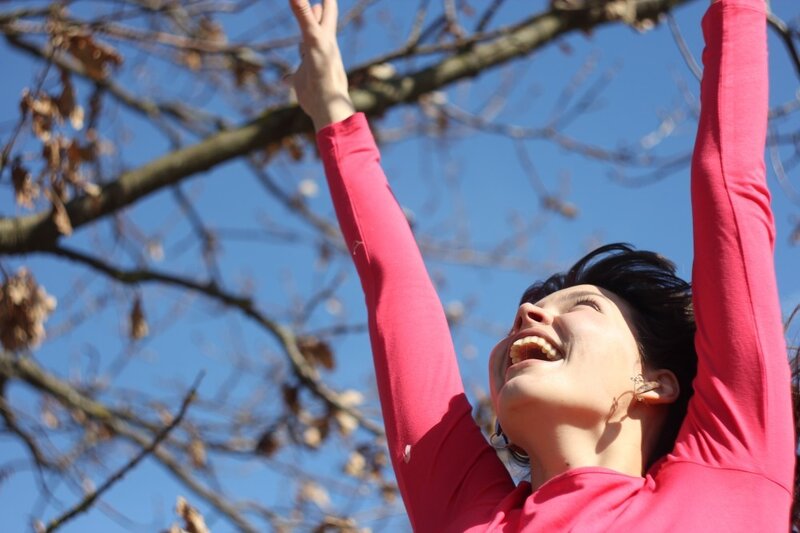 Woman laughing with arms raised