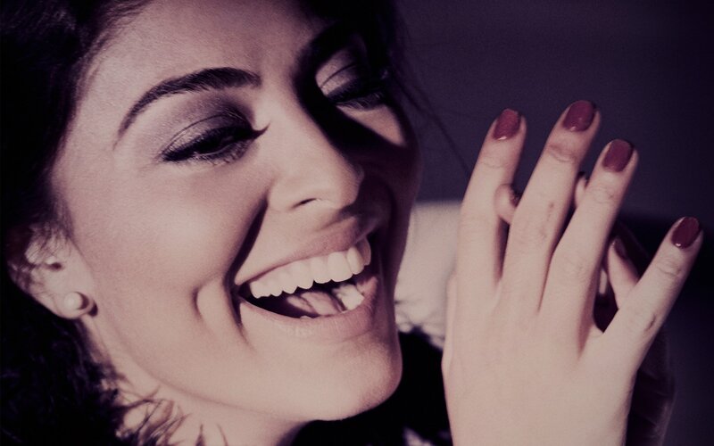 woman laughing with hand near face
