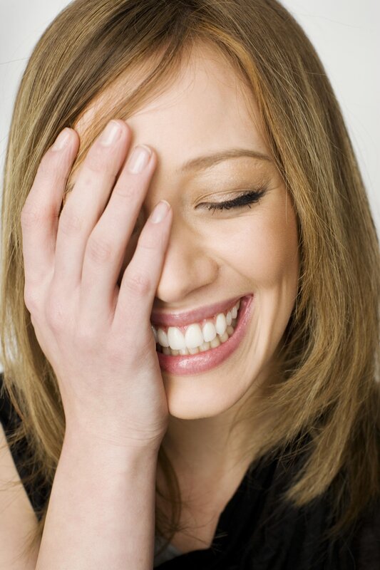 woman laughing with hand on face