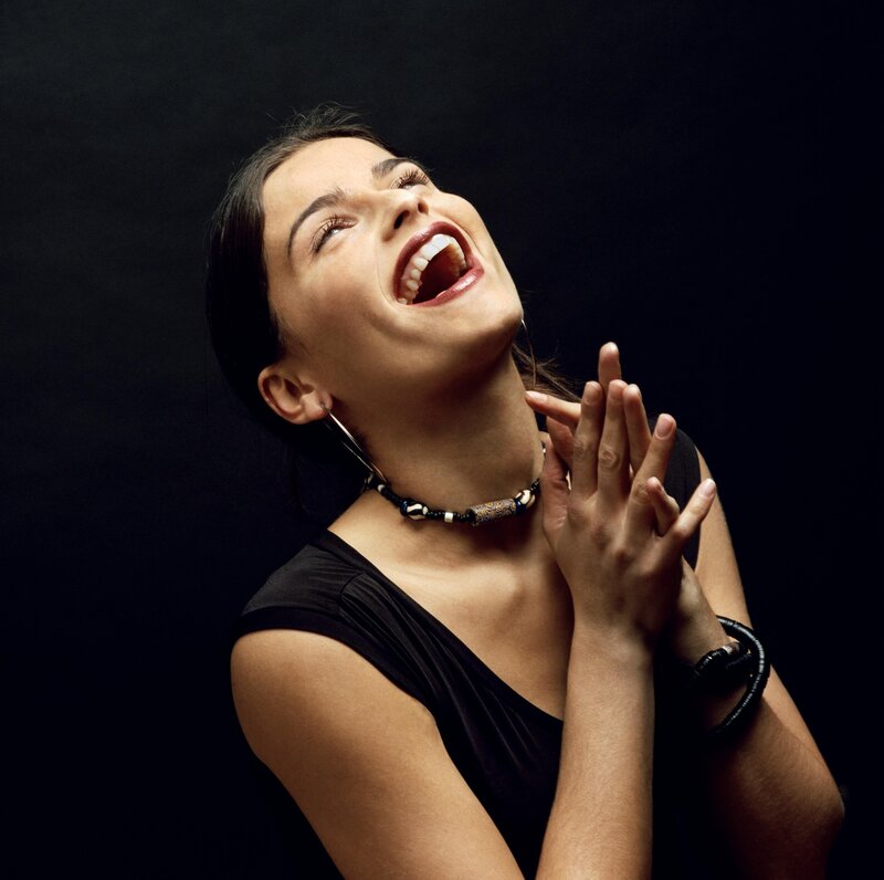 woman laughing with hands clasped