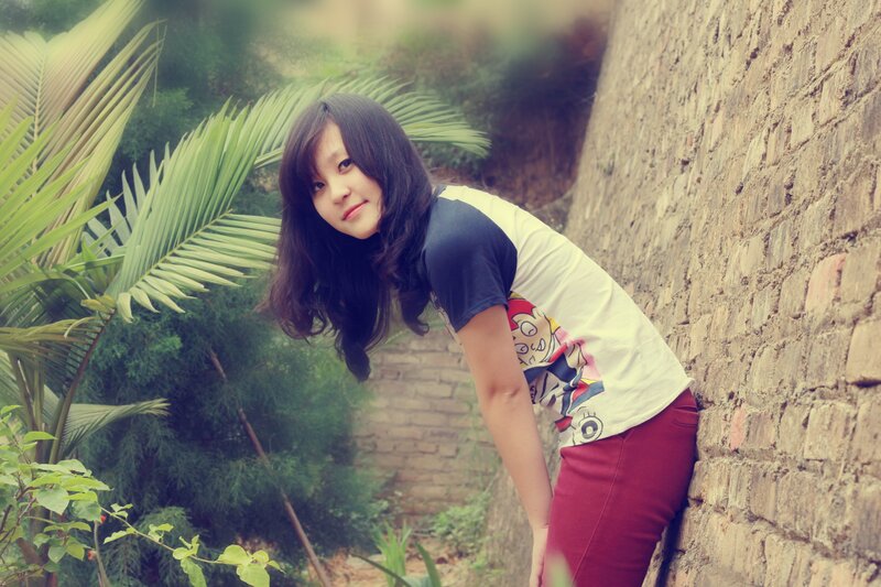 woman leaning against a brick wall