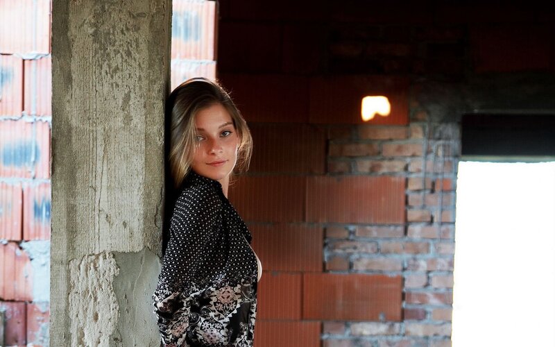 woman leaning against a pillar