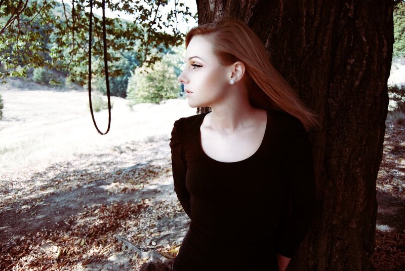 woman leaning against a tree