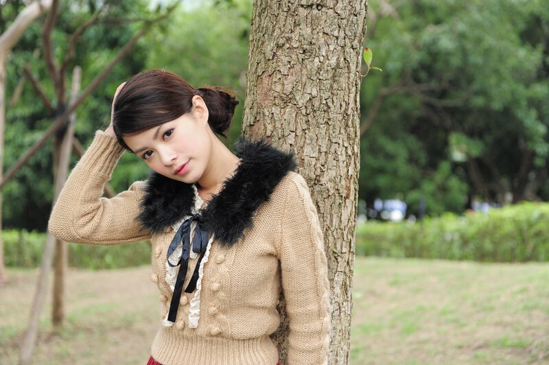 woman leaning against a tree