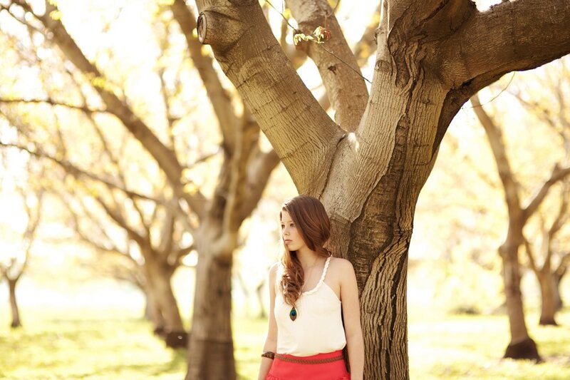 woman leaning against a tree