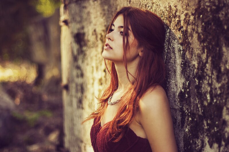 woman leaning against a tree
