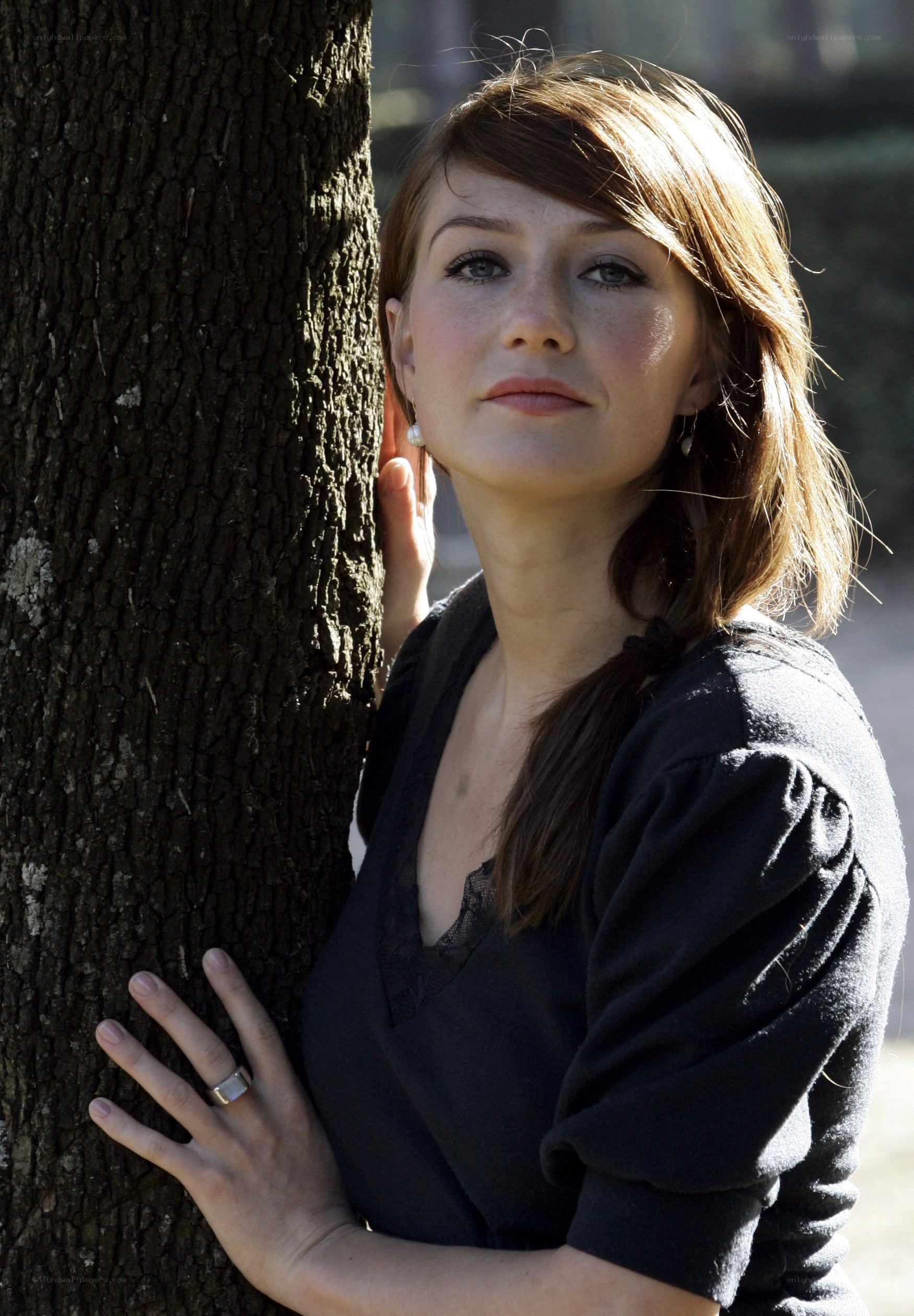 woman leaning against a tree