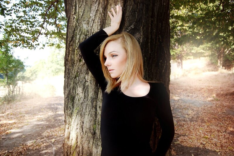 woman leaning against a tree