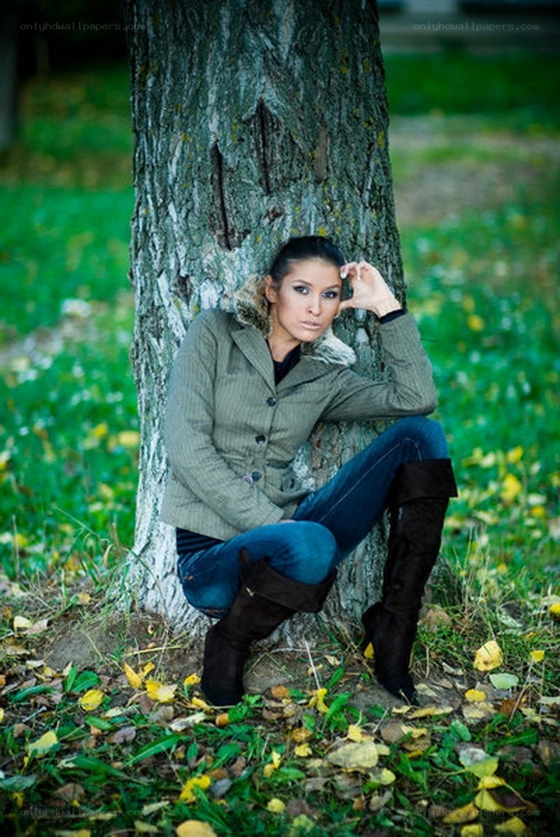 woman leaning against a tree