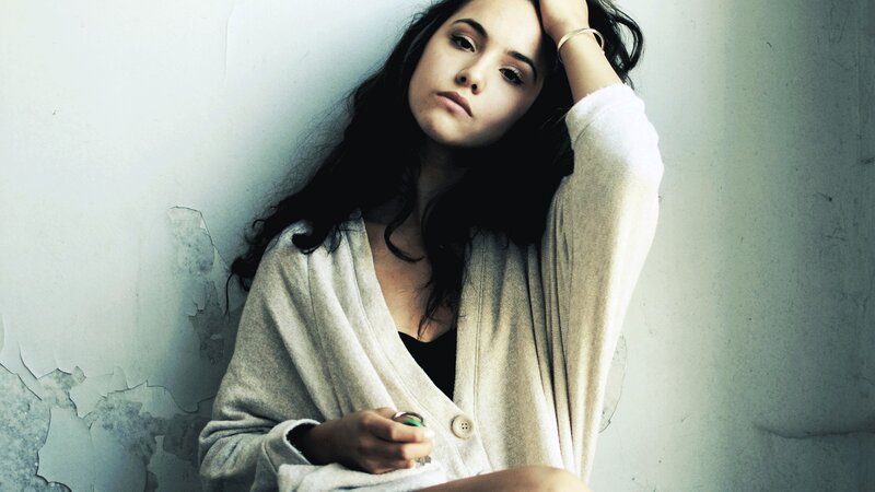 woman leaning against a wall