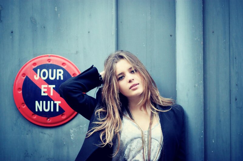 woman leaning against blue wall
