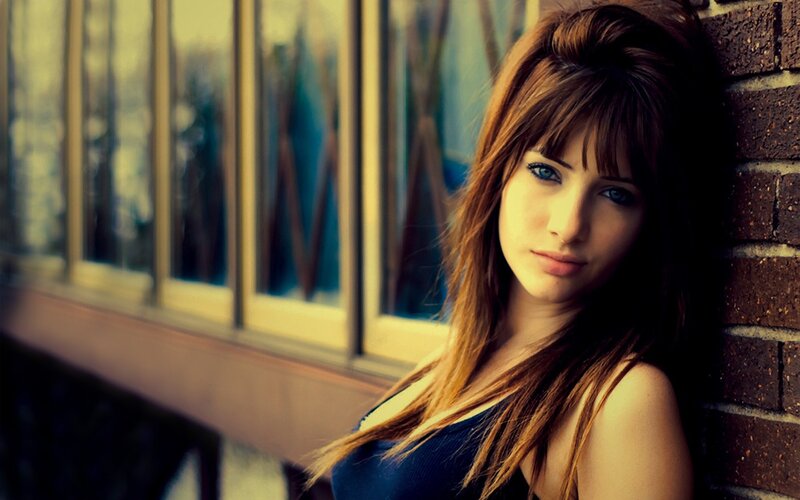 woman leaning against brick wall
